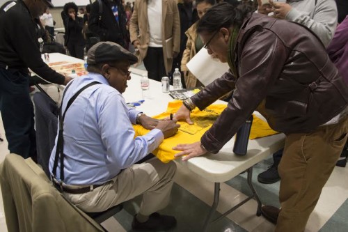 Bobby Seale autographing books, posters, and more [Image from Ariel Zuniga]
